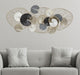 Panou decorativ Luxy montat pe perete deasupra unei canapele gri